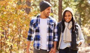 African American Couple Walking Through Fall Woodland
